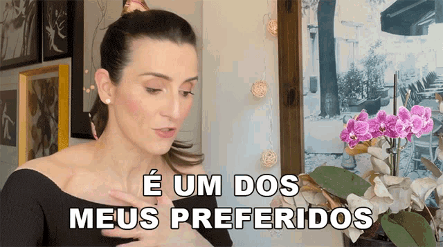 a woman says e um dos meus preferidos in a room with flowers