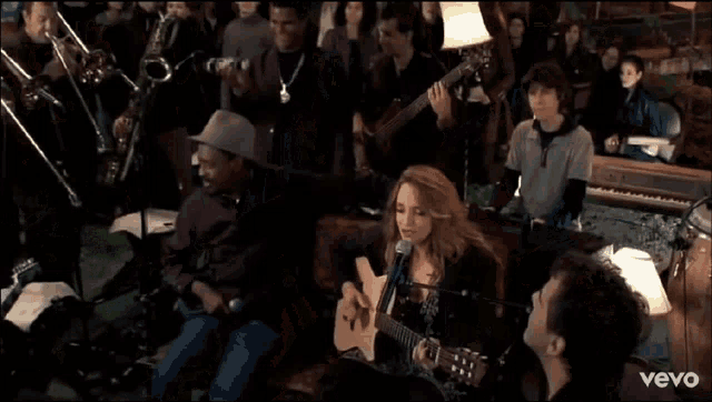 a man in a hat is talking to a woman in front of a microphone that says vevo on the bottom