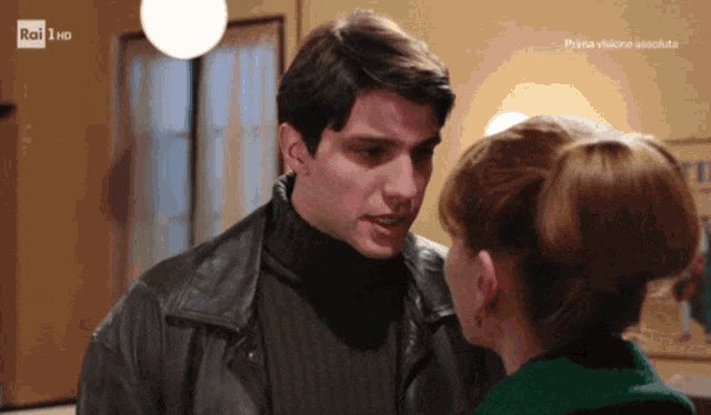 a man and woman are looking into each other 's eyes with rai 1 hd behind them