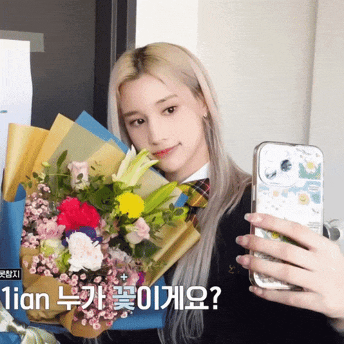 a girl is taking a picture of herself with a bouquet of flowers behind her