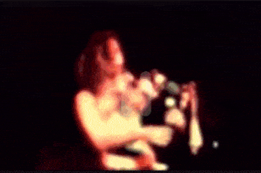 a blurred image of a person singing into a microphone