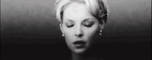 a black and white photo of a woman with her eyes closed and her mouth open .