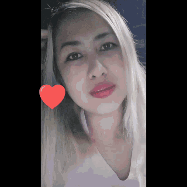 a close up of a woman 's face with a heart in the background