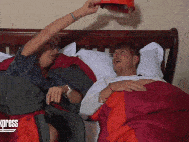 a man and a woman are laying on a bed with a blanket that says express