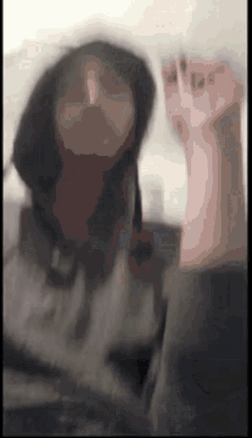 a blurry picture of a person 's face and their hand
