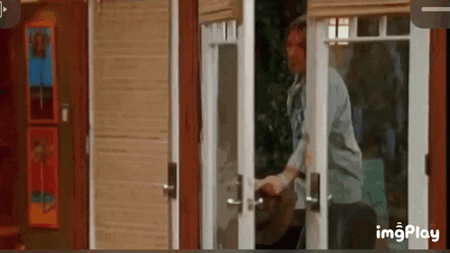 a man is standing in front of a sliding glass door in a house .