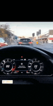 a car is driving down a street and the dashboard shows the speed as 26 mph