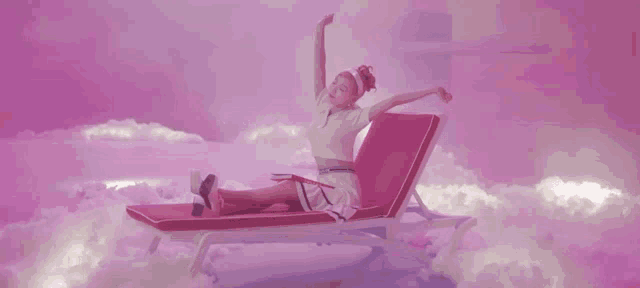 a woman is sitting on a lounge chair in the clouds with her arms outstretched