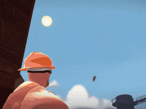 a man in an orange hard hat looks at a man flying in the air