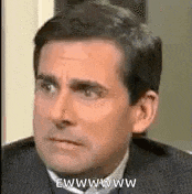 a man in a suit and tie is making a funny face while looking at the camera .