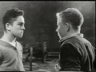 a black and white photo of two men standing next to each other .