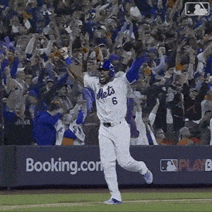 a baseball player wearing a mets jersey is running on the field with his arms in the air