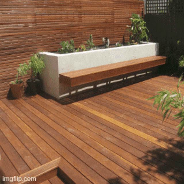 a picture of a wooden deck with a bench and a planter with the website imgflip.com at the bottom