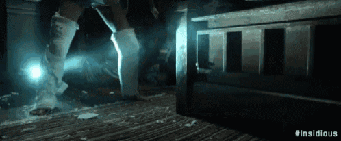 a person with a bandage on their leg is standing in a dark room with a light shining on them .