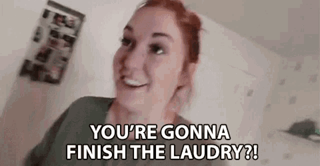 a woman is standing in a room with the words `` you 're gonna finish the laundry '' written on her face .