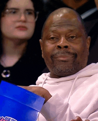a man in a white hoodie holds a blue box that says new york