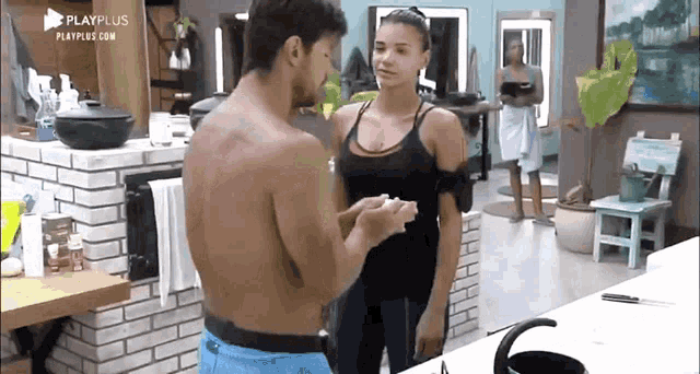 a man and a woman are standing next to each other in a room .