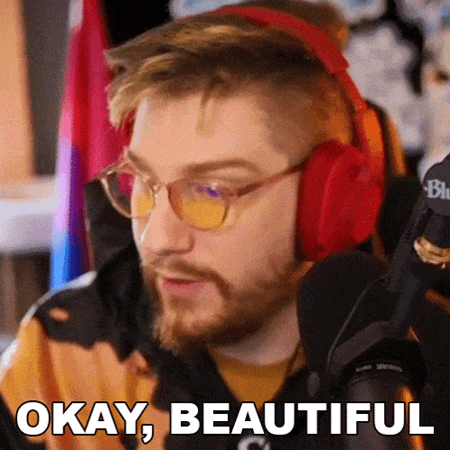 a man wearing red headphones and glasses is saying okay beautiful
