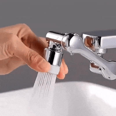 a person is cleaning a sink with a brush attached to a faucet .