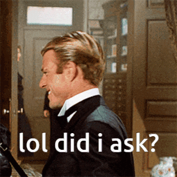 a man in a suit says lol did i ask while standing in front of a door