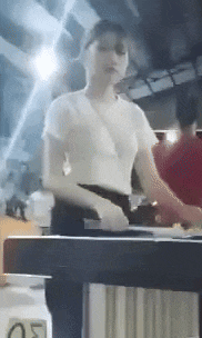 a woman is standing behind a counter in a restaurant .