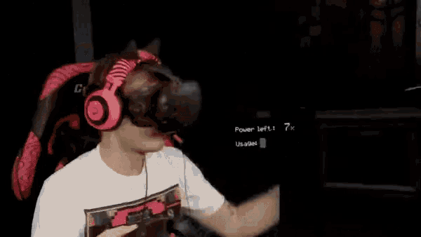 a man wearing headphones is playing a video game in the dark