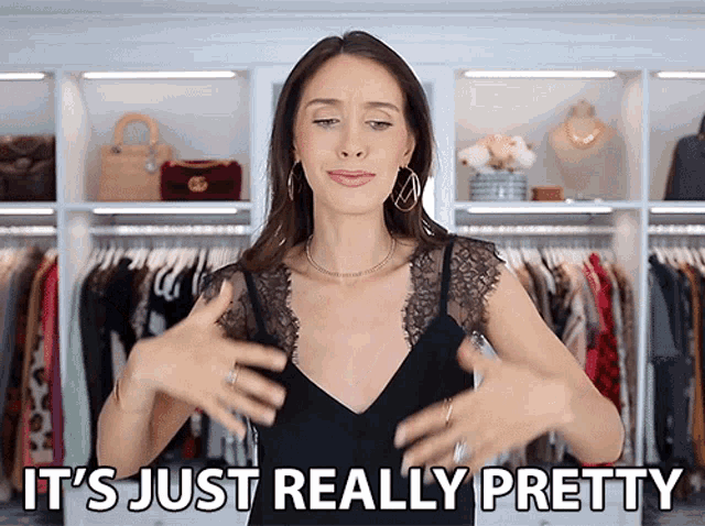 a woman in a black lace top is standing in front of a closet and says it 's just really pretty