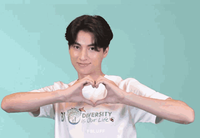 a man making a heart shape with his hands wearing a shirt that says diversity is our life