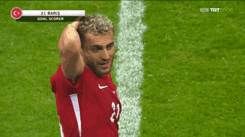 a soccer player wearing a red shirt with the number 21 on it