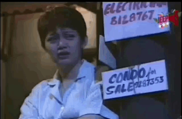 a woman is sitting in front of a sign that says condo for sale .