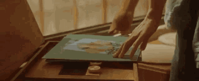 a person is putting a picture in a box .