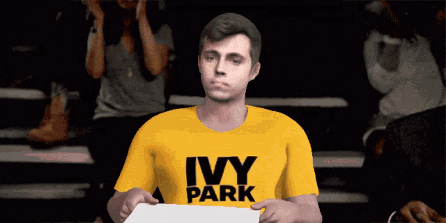 a man wearing a yellow shirt that says ivy park holds a piece of paper