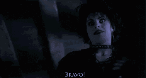 a person is holding a knife in their hand in a dark room and says `` bravo '' .