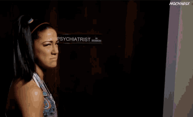 a woman stands in front of a door that says psychiatrist