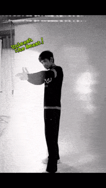 a man standing in front of a white wall with the words " unlock the beast " on it