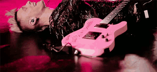 a person laying on the floor with a pink guitar that says ' i love you ' on it
