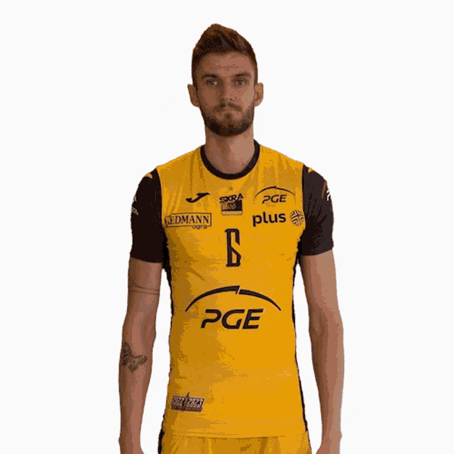 a man in a yellow pge plus shirt stands in front of a white background