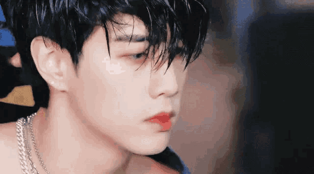 a close up of a man 's face with wet hair and red lipstick .