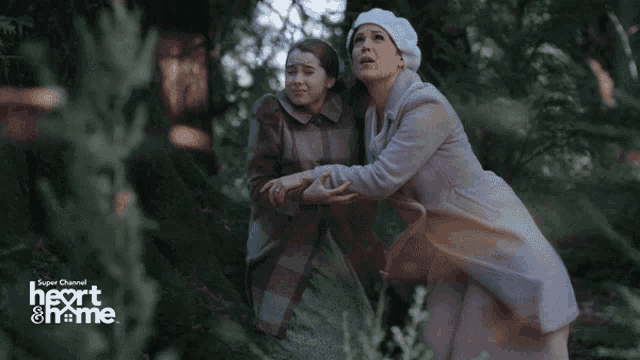 two women are running through a forest with the words heart & home behind them