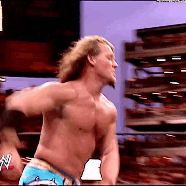 a wrestler without a shirt is standing in front of a stack of boxes