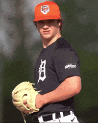 a man wearing an orange hat and a black shirt with the letter d on it