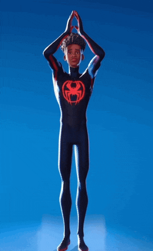 a man in a spider man suit is standing with his hands up in the air
