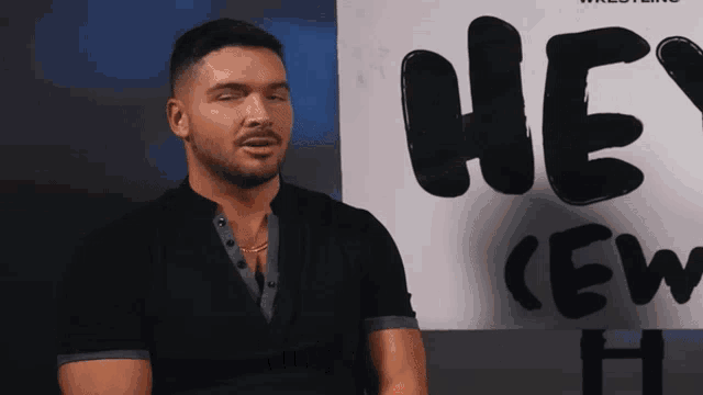 a man stands in front of a poster that says hey crew