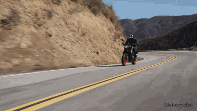 a person riding a motorcycle on a road with the word motorcyclist on the bottom right