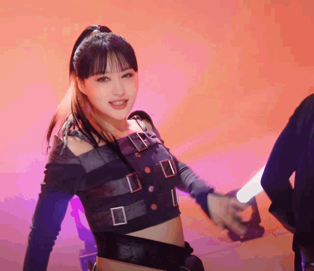 a woman in a ponytail is smiling and holding a light