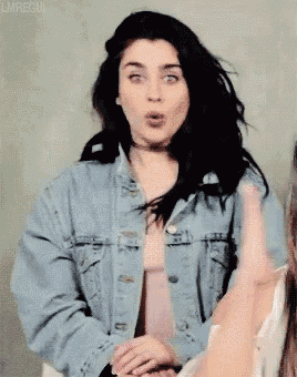 a woman is wearing a denim jacket and a choker .