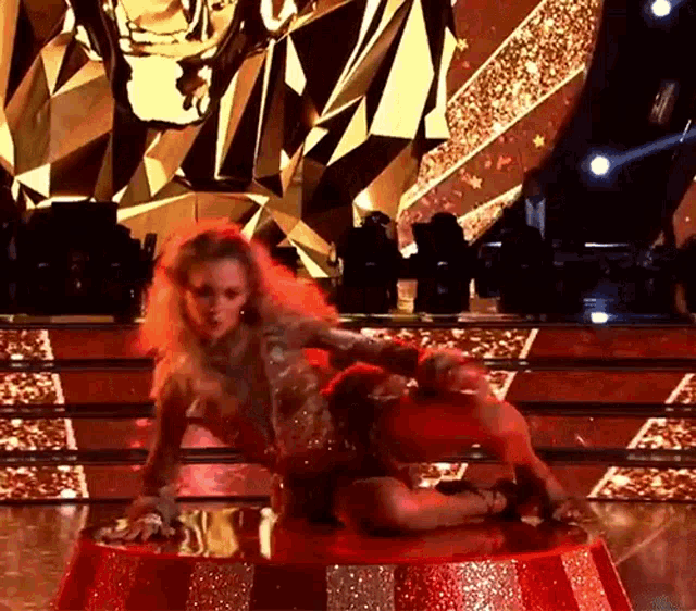 a woman is dancing on a stage in a red and white striped dress .