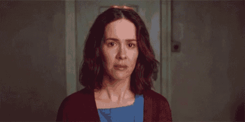 a close up of a woman 's face with a red sweater and blue dress .