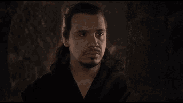 a man with long hair and a beard is asking the question quoi