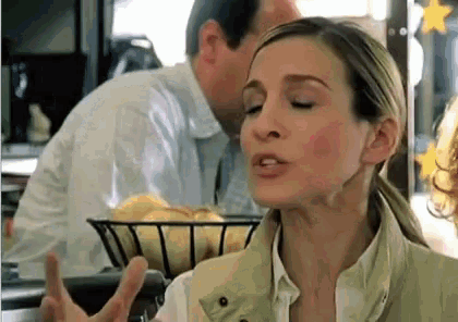a woman is making a funny face while a man looks on .